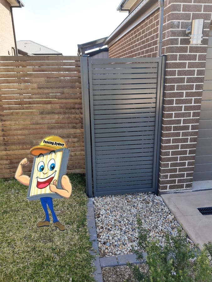 Dark grey aluminium horizontal slat pedestrian gate hung between a brick pier and a horizontal timber screen fence